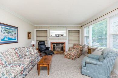 The living room features built-in shelving, gas fireplace, crown molding, and large vinyl replacement windows that allow for lots of natural light!