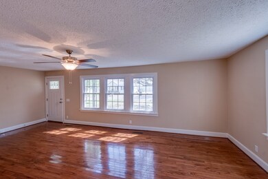Spacious Living Room/Family Rm with Ceiling Fan.  Hardwood floors were just refinished, new windows, ceiling fan and whole room freshly painted!  Open to the Dining Room off the kitchen. 