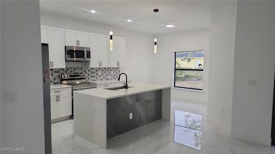Kitchen featuring pendant lighting, sink, white ca