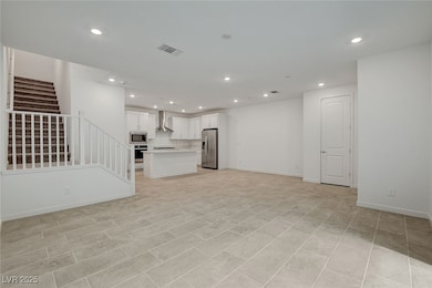 Unfurnished living room with recessed lighting and stairway