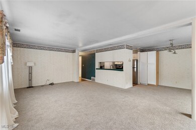Unfurnished living room with wallpapered walls and light carpet