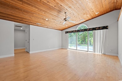Spare room featuring lofted ceiling, wood ceiling, a ceiling fan, and light wood finished floors