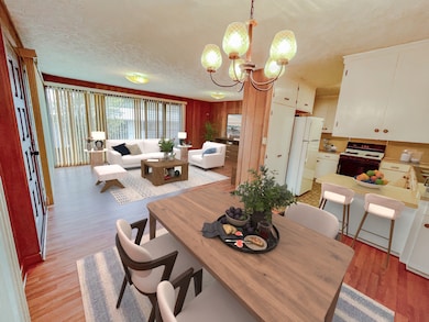 Dining area looking towards living room with the kitchen to the right (virtually staged).