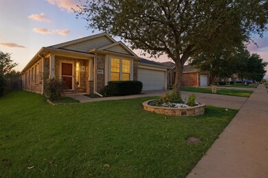 View of front of house featuring driveway, a front lawn, brick siding, and an attached garage