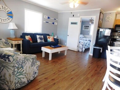 Living room with crown molding, wood finished floors, and ceiling fan