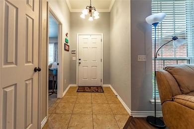 Foyer featuring a chandelier, baseboards, ornament
