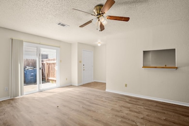 Unfurnished room with visible vents, a textured c