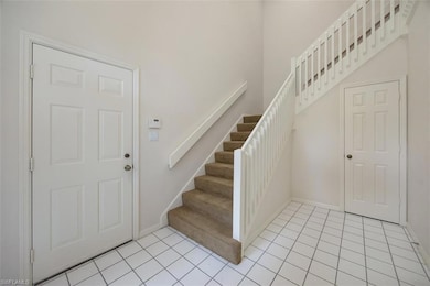 Foyer entrance with stairway, baseboards, and ligh