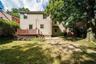 Back of property featuring a yard and wooden deck