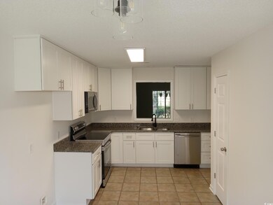 Kitchen featuring a textured ceiling, light tile p