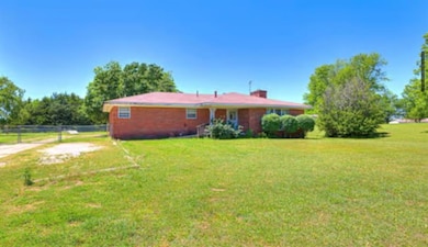 Rear view of property featuring a yard and brick siding