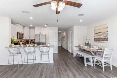 Kitchen with stainless steel appliances, a peninsula, dark wood-type flooring, recessed lighting, and white cabinets