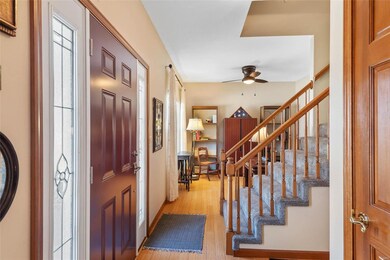 Entryway featuring light wood-type flooring, a ceiling fan, and stairway