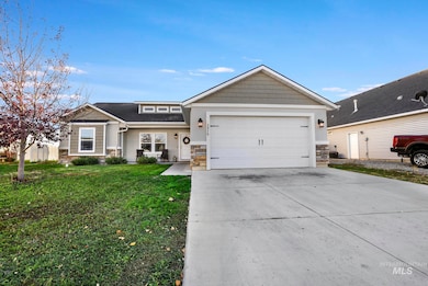 View of front of home with stone siding, driveway, a front lawn, a garage, and a shingled roof