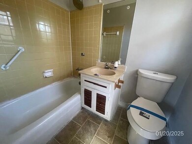 Full bath featuring bathing tub / shower combination, vanity, and stone finish floors