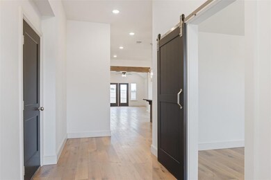 Hall featuring a barn door and light hardwood / wo