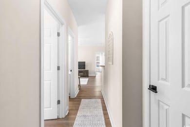 Hallway featuring light wood-style flooring and baseboards