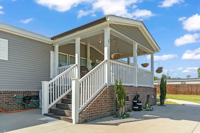 Property entrance with fence, a porch, and brick s