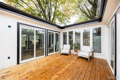 Sunroom / solarium featuring hardwood / wood-style floors and wood walls