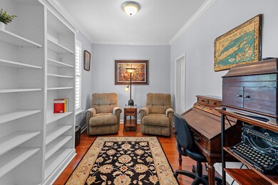 First floor bedroom currently being used as an office with built-in shelving and a walk-in closet.