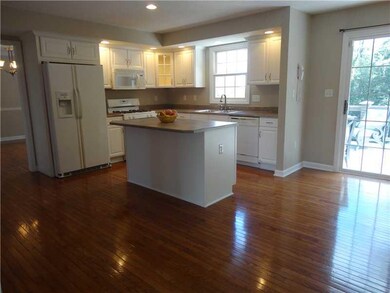 Kitchen. This incredible kitchen offers gleaming hardwood floors, recessed lighting, beautiful white cabintery with one display cabinet to show off your favorite dishes, and access to the phenomenal deck via a slider.