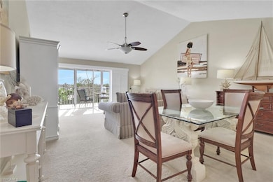 Dining area with light carpet, vaulted ceiling, and a ceiling fan