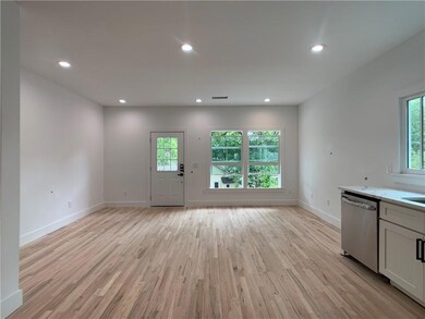 Living room with tons of natural lighting and hardwood floors
