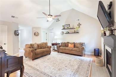Living area with lofted ceiling, ceiling fan, a fi