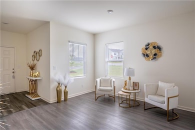 Sitting room with dark wood finished floors and baseboards