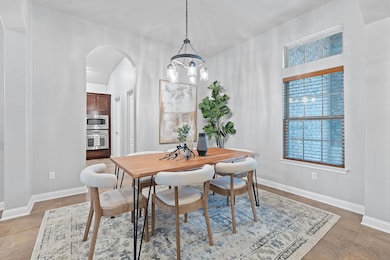 Dining space with arched walkways, a chandelier, 