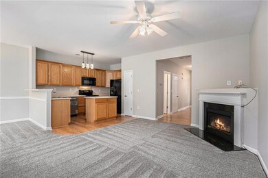 Kitchen featuring black appliances, light carpet, light countertops, and open floor plan