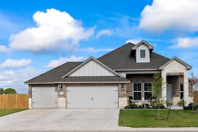 View of front of home with a shingled roof, an attached garage, brick siding, stone siding, and board and batten siding