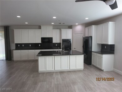 Kitchen featuring dark countertops, white cabinets