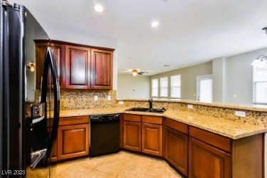 Kitchen with black appliances, a peninsula, light