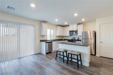 Kitchen featuring dark countertops, dark wood fini