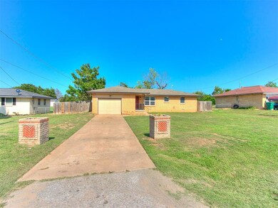 Single story home featuring a garage and a front y