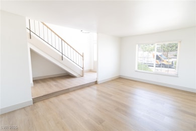Unfurnished living room featuring wood finished fl