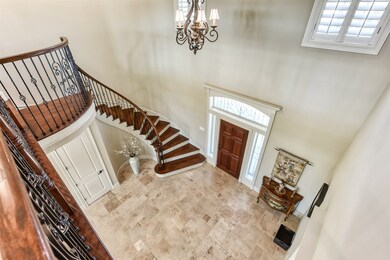 The foyer with the double height ceiling, curved staircase, twisted iron spindles, and Juliet balcony creates a memorable first impression.