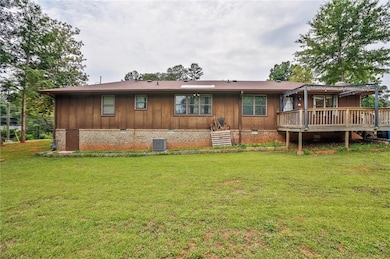 Rear view of house featuring crawl space, a deck, a yard, and central air condition unit