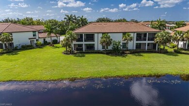 Back of property featuring a water view and a lawn