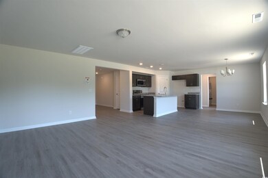 Unfurnished living room with a chandelier, dark wood-type flooring, and recessed lighting