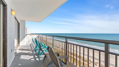 Balcony featuring view of water and beach