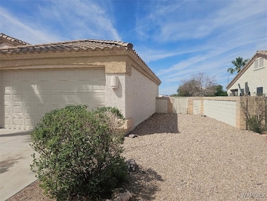 View of side of property with a tile roof, a gate,