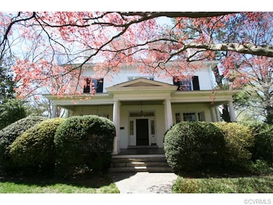 Covered front porch and mature landscaping create a private space to enjoy the beautiful setting.