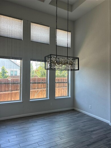 Spare room with a chandelier and wood finished fl
