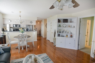 Living room with baseboards, light wood-type floor
