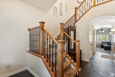 Staircase with a ceiling fan and arched walkways