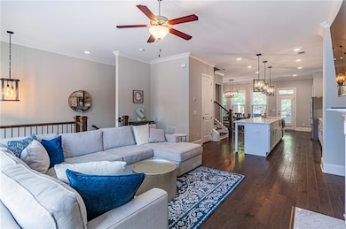 Living room featuring a chandelier, recessed lighting, baseboards, stairway, and a ceiling fan