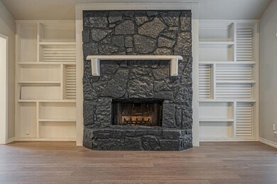 Unfurnished living room with a stone fireplace and