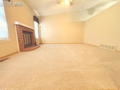Unfurnished living room featuring lofted ceiling, a fireplace, carpet floors, and ceiling fan